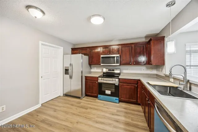a kitchen with stainless steel appliances granite countertop a refrigerator stove top oven a sink and dishwasher
