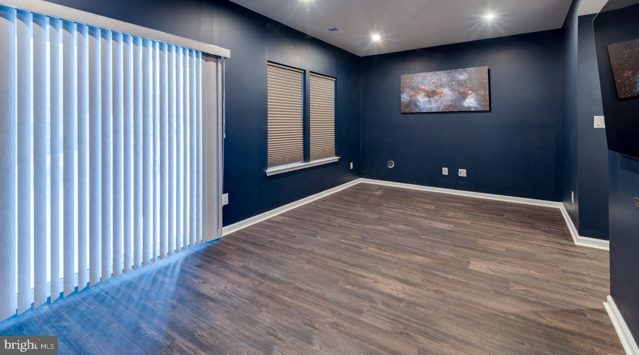44596 Nolani Way California, MD 20619 - Photo 14 of 31 a view of an empty room with wooden floor and a flat screen tv