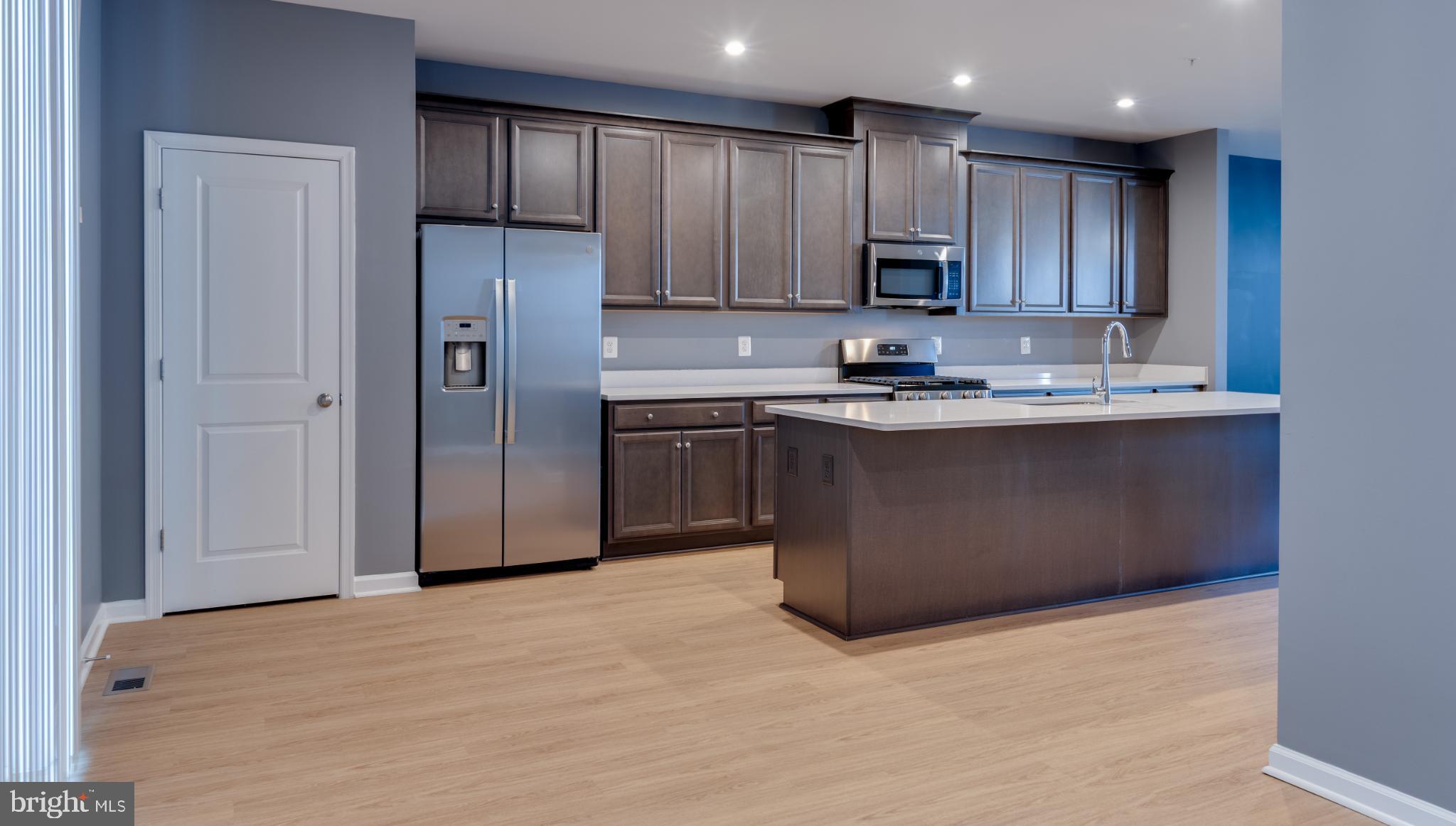 44596 Nolani Way California, MD 20619 - Photo 9 of 31 a kitchen with stainless steel appliances granite countertop a stove a refrigerator and a sink with wooden cabinets