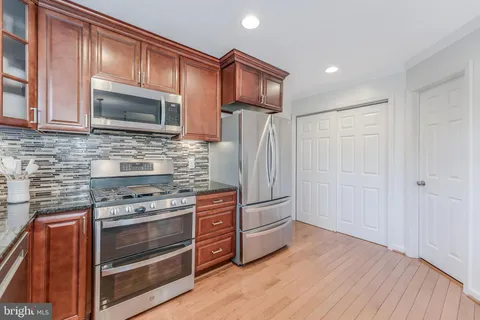 a kitchen with stainless steel appliances granite countertop wooden cabinets stove top oven and sink