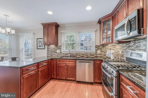 a kitchen with stainless steel appliances granite countertop a stove sink and cabinets