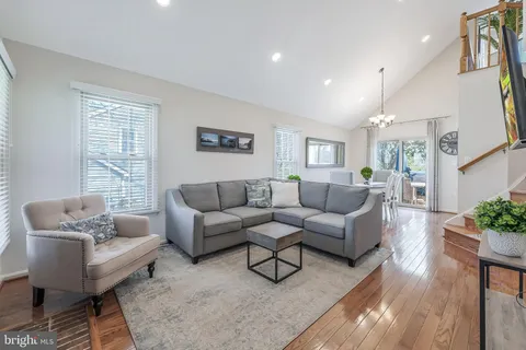 a living room with furniture wooden floor and a large window