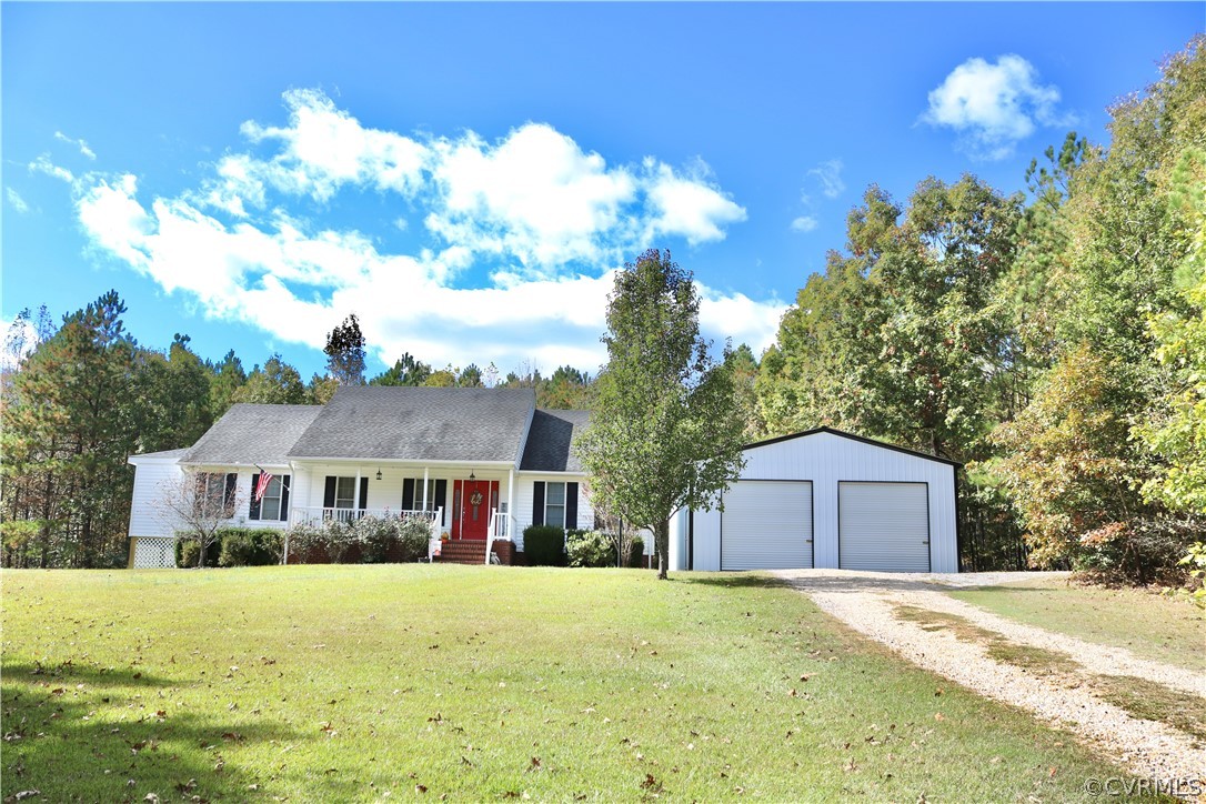 a front view of house with yard and trees in the background