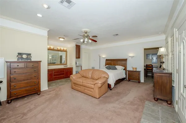 a spacious bedroom with a bed and dresser