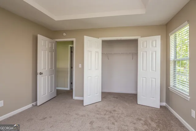 an empty room with windows and closet