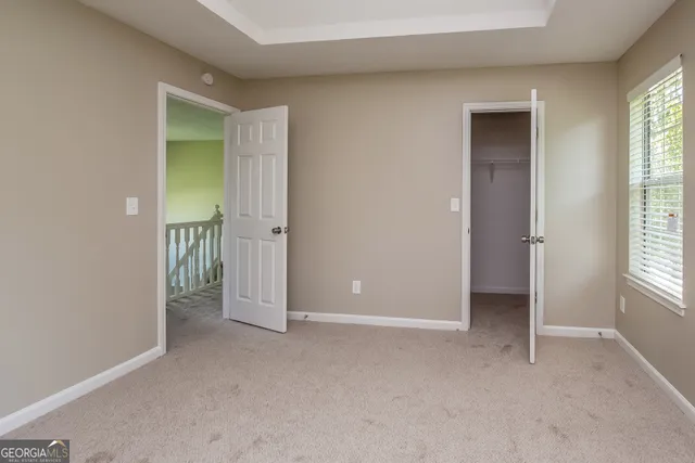 an empty room with windows and closet