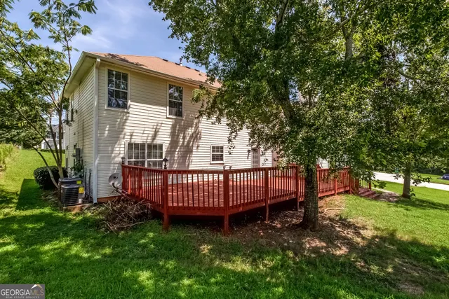 a view of a house with a yard and deck