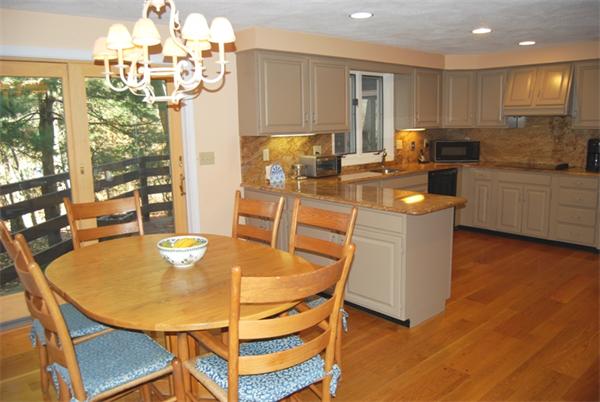 237 East Emerson Road Lexington, MA 02420 - Photo 9 of 22 a kitchen with stainless steel appliances granite countertop a stove a kitchen island a refrigerator and a dining table with wooden floor