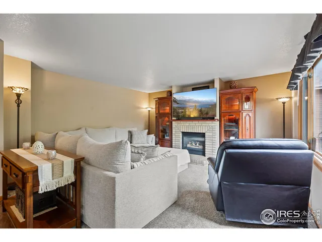 a living room with furniture a fireplace and a large mirror