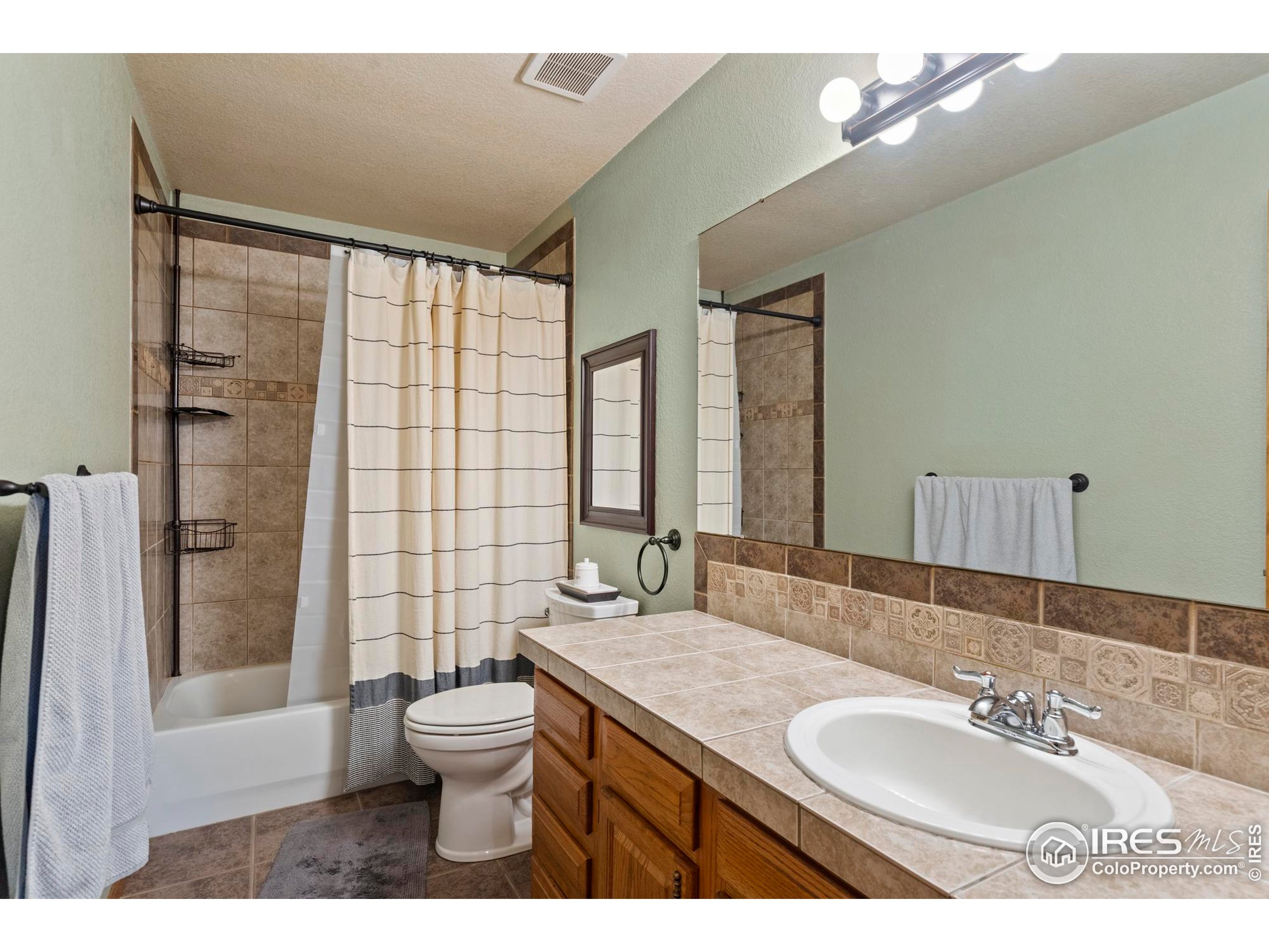 1808 Silvergate Road Fort Collins, CO 80526 - Photo 22 of 42 a bathroom with a double vanity sink toilet mirror and shower