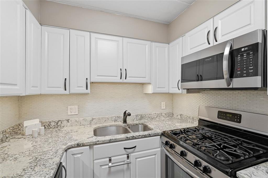 5 Bayard Road, Unit 520 Pittsburgh, PA 15213 - Photo 9 of 25 a kitchen with stainless steel appliances granite countertop a sink stove and microwave