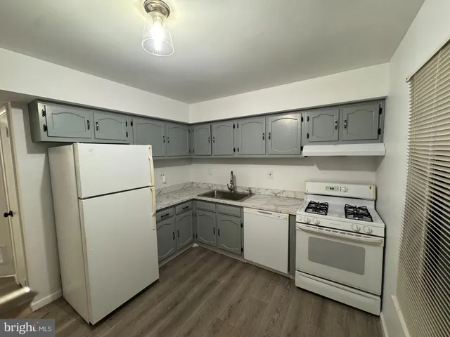 a kitchen with a stove refrigerator sink and cabinets