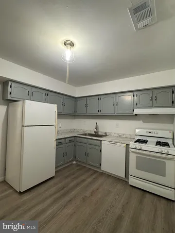 a kitchen with a refrigerator stove and white cabinets