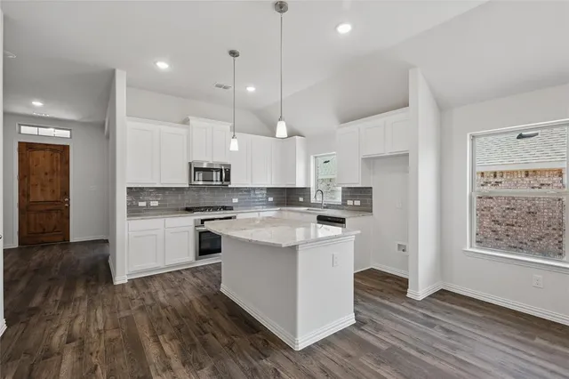 a kitchen with kitchen island white cabinets and white appliances