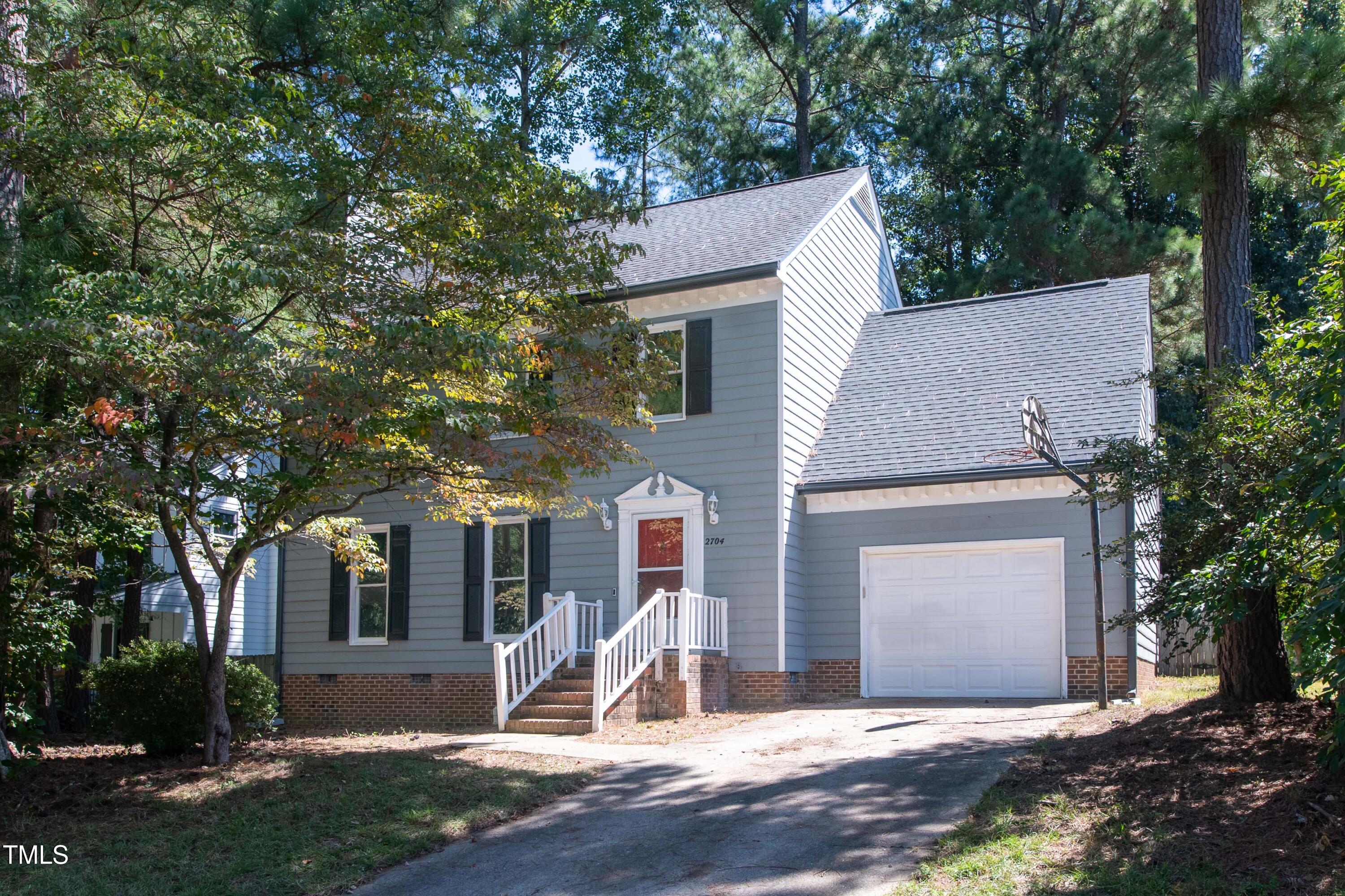 a view of a house with a yard and large tree