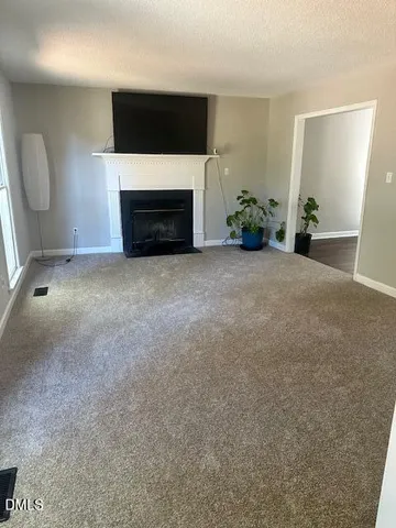 a living room with a fireplace and a flat screen tv