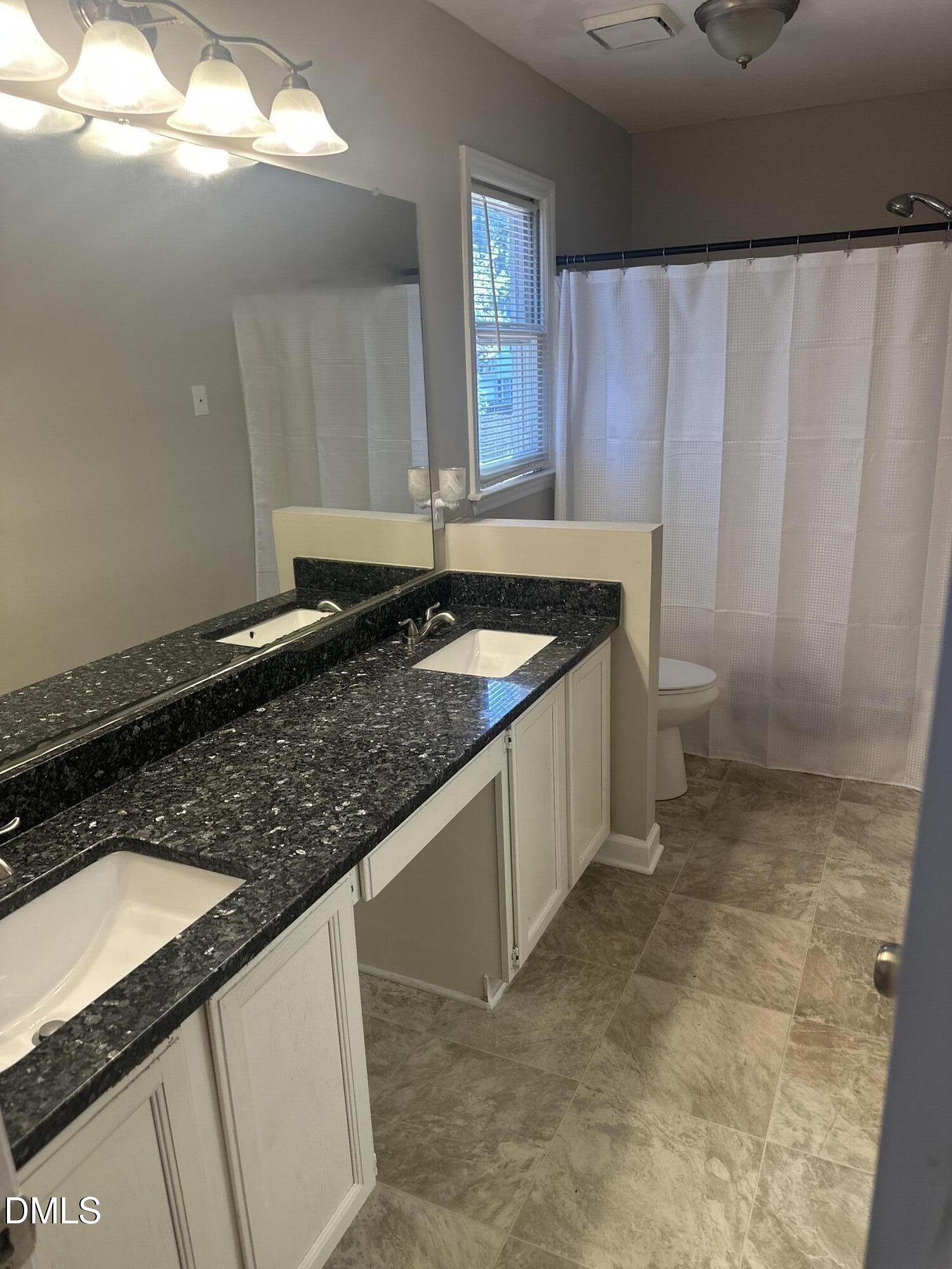 2704 Rockbridge Court Raleigh, NC 27604 - Photo 13 of 15 a bathroom with a granite countertop sink and a mirror