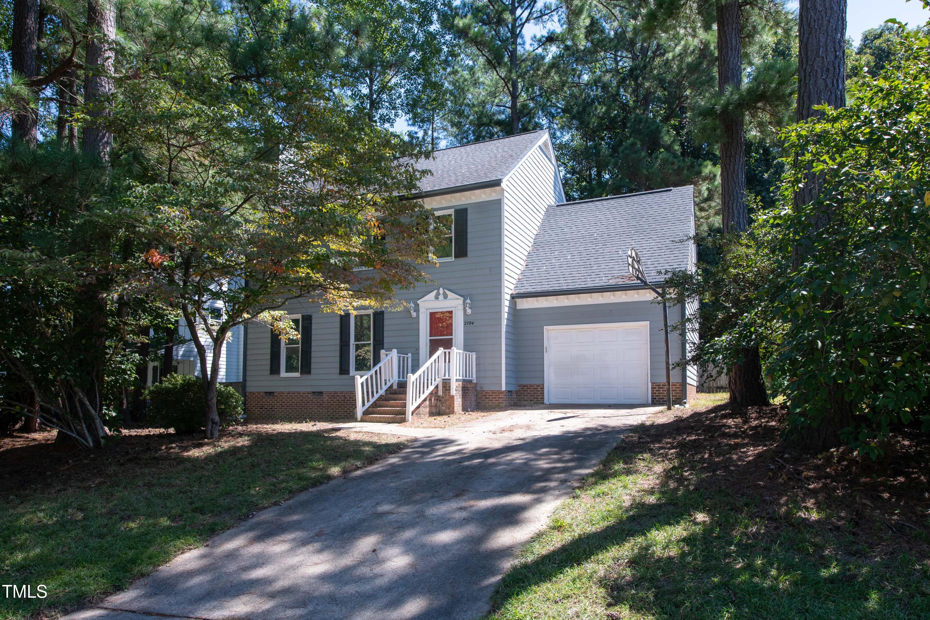 2704 Rockbridge Court Raleigh, NC 27604 - Photo 2 of 15 a view of a white house with a yard and large tree