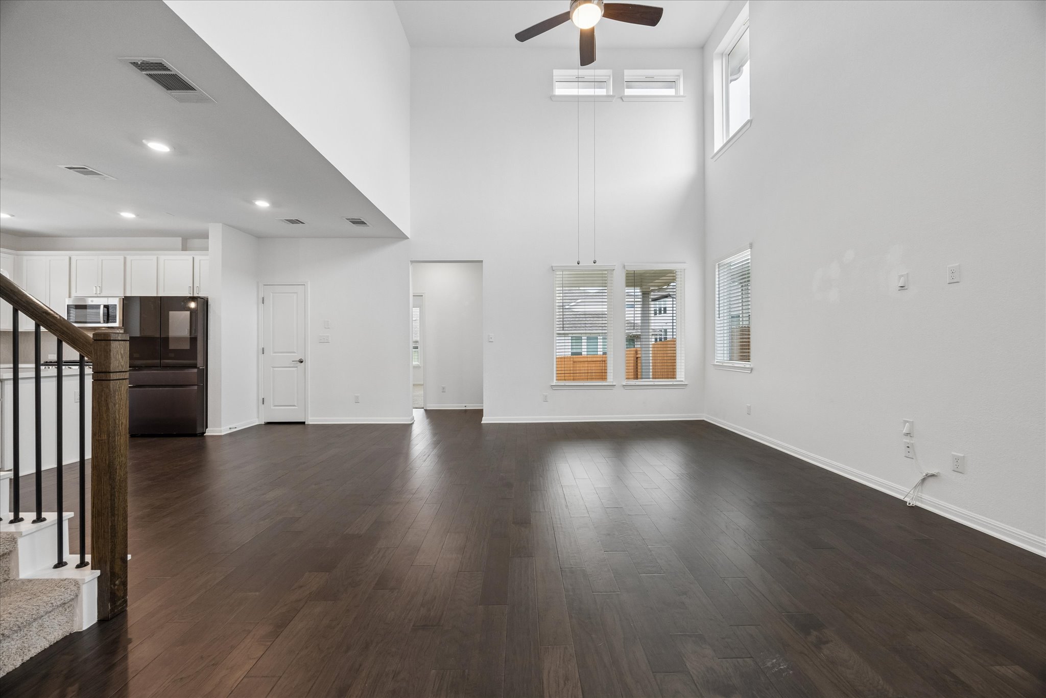 6407 Rounded Pebble Lane Buda, TX 78610 - Photo 8 of 32 A grand living space with towering ceilings and rich hardwood flooring, perfect for entertaining.