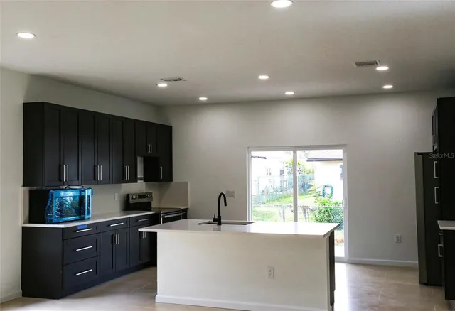 a kitchen with granite countertop cabinets stainless steel appliances and a window