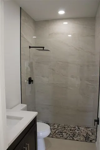 a bathroom with a sink a toilet and shower