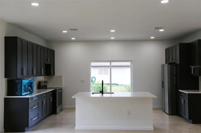 a kitchen with a refrigerator and a stove top oven