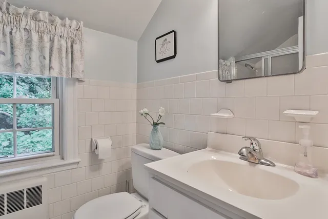 a bathroom with a sink a toilet and a mirror