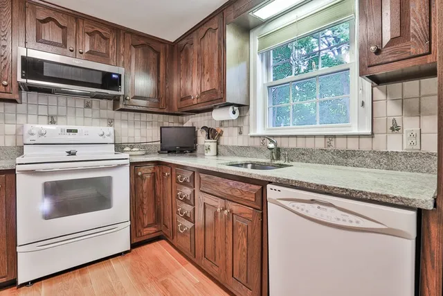 a kitchen with granite countertop a sink stainless steel appliances and cabinets