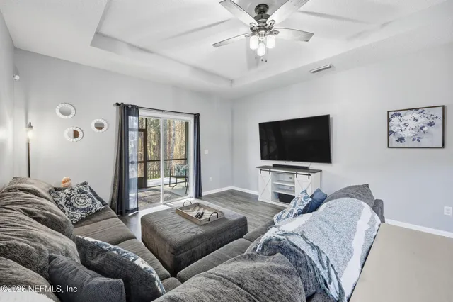 a living room with furniture and a view of kitchen