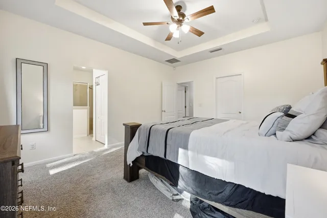 a spacious bedroom with a bed and a chandelier