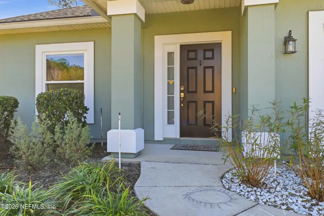 a front view of a house with a potted plant and a window