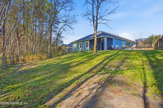 a view of a house with a big yard and large trees