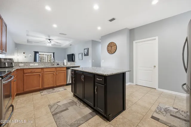 a kitchen with stainless steel appliances granite countertop a stove top oven a sink a counter top space and cabinets