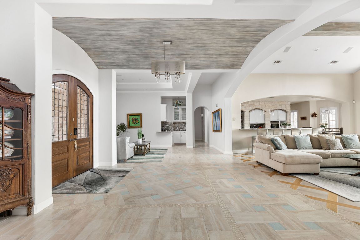 805 Brooks Hollow Road Lakeway, TX 78734 - Photo 6 of 38 a living room with furniture and a chandelier