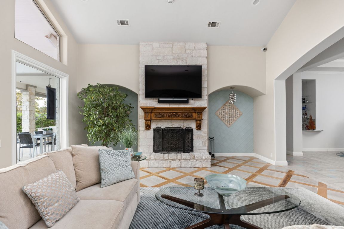 805 Brooks Hollow Road Lakeway, TX 78734 - Photo 7 of 38 a living room with furniture a flat screen tv and a fireplace