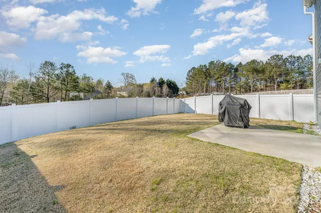 a view of an house with backyard and a tree