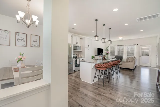 a view of a dining room with furniture a chandelier and wooden floor