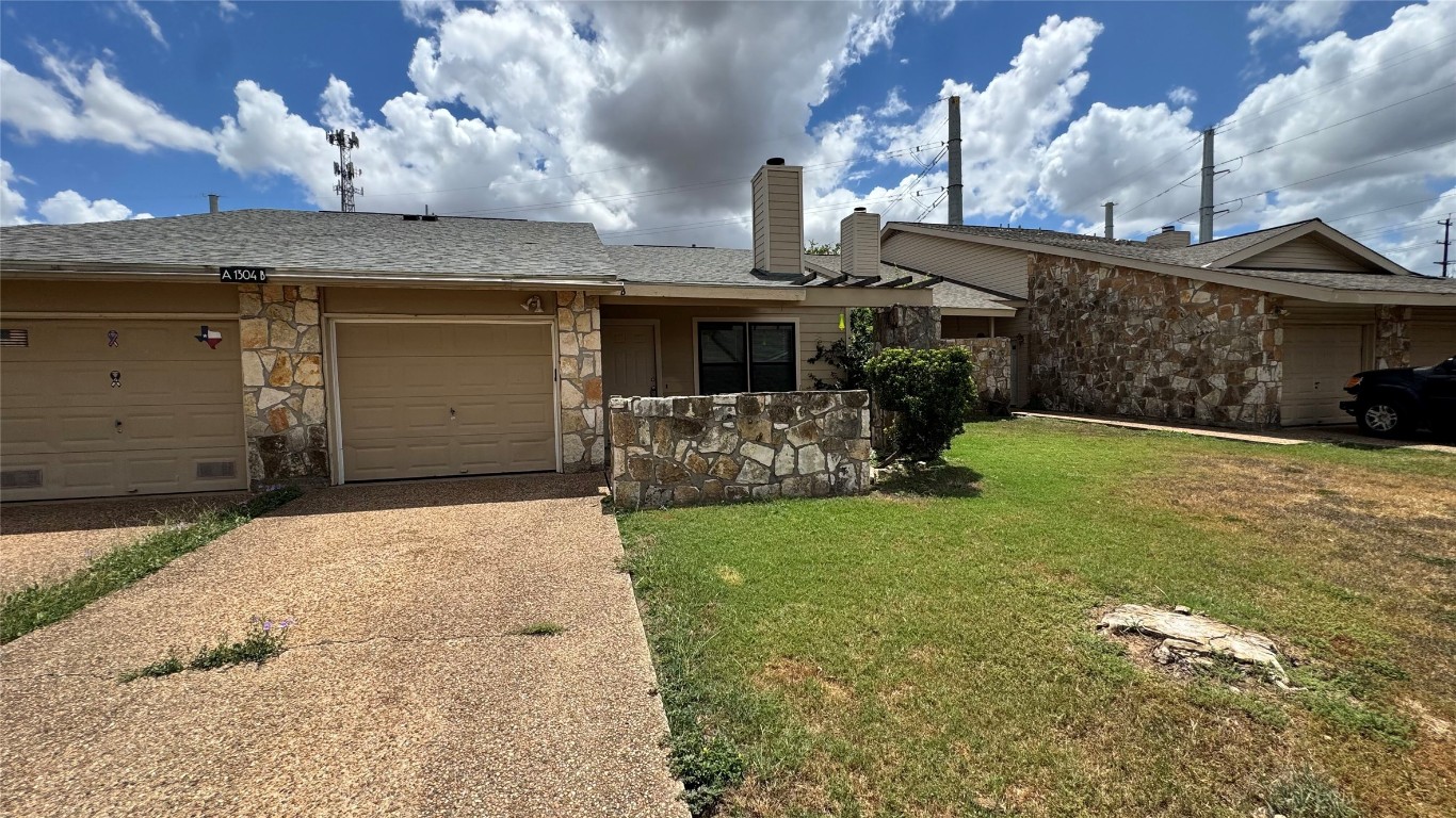 1304 Conway Drive, Unit B San Marcos, TX 78666 - Photo 14 of 16 a front view of a house with a yard and garage
