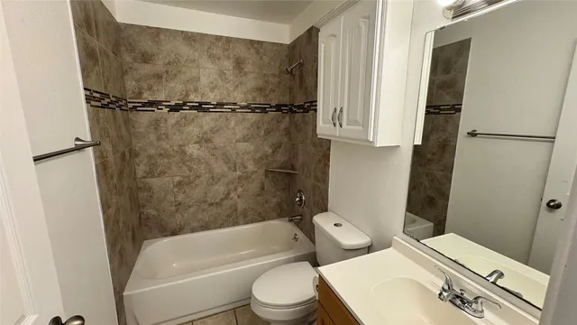 a white toilet sitting next to a bath tub and a shower