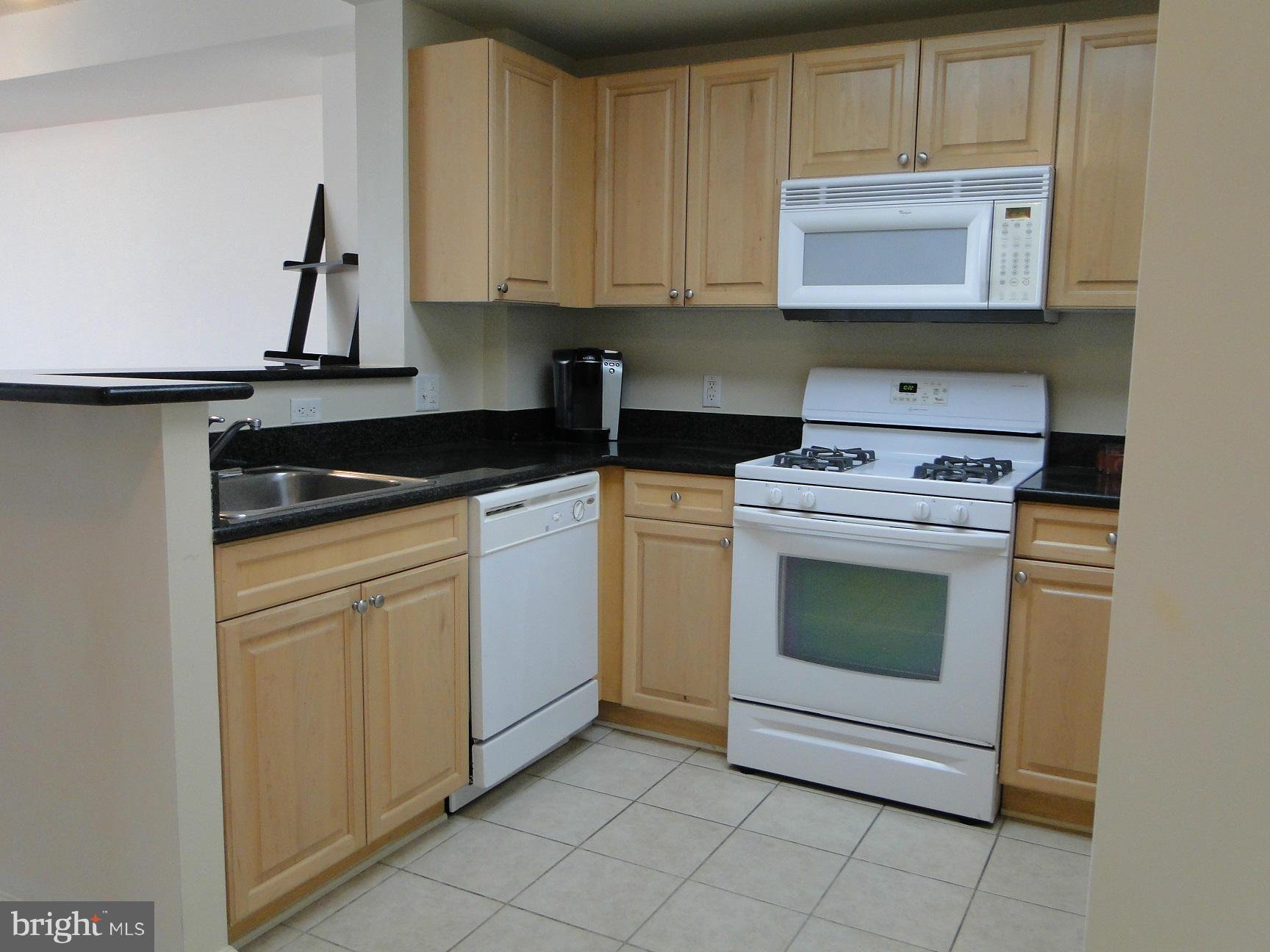 2726 Gallows Road, Unit 611 Vienna, VA 22180 - Photo 2 of 29 a kitchen with granite countertop white cabinets sink and stainless steel appliances