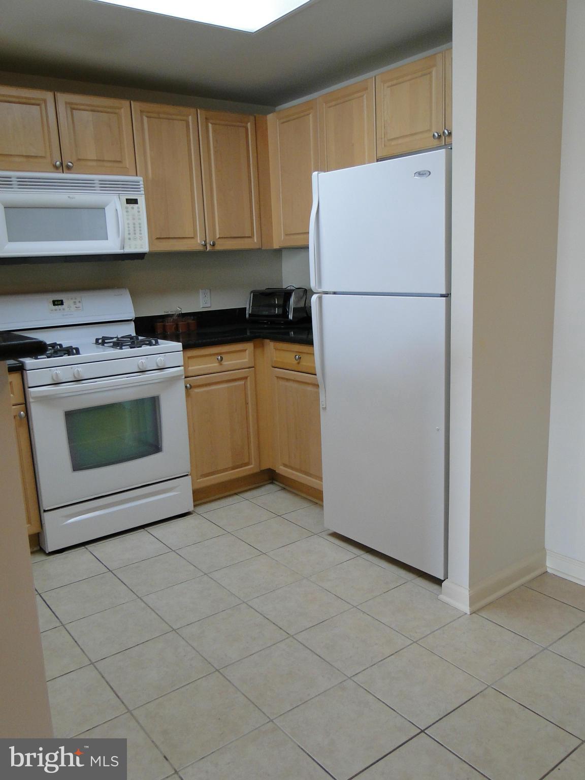 2726 Gallows Road, Unit 611 Vienna, VA 22180 - Photo 4 of 29 a white refrigerator freezer and a stove sitting inside of a kitchen