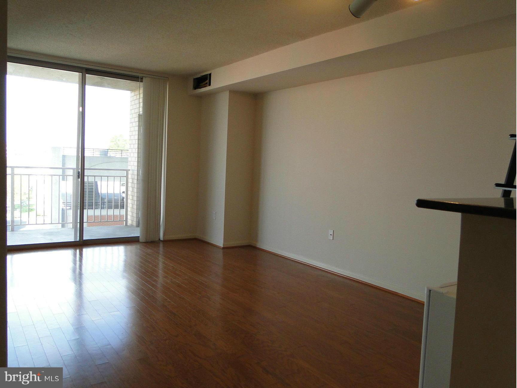 2726 Gallows Road, Unit 611 Vienna, VA 22180 - Photo 6 of 29 a view of an empty room with wooden floor and a window
