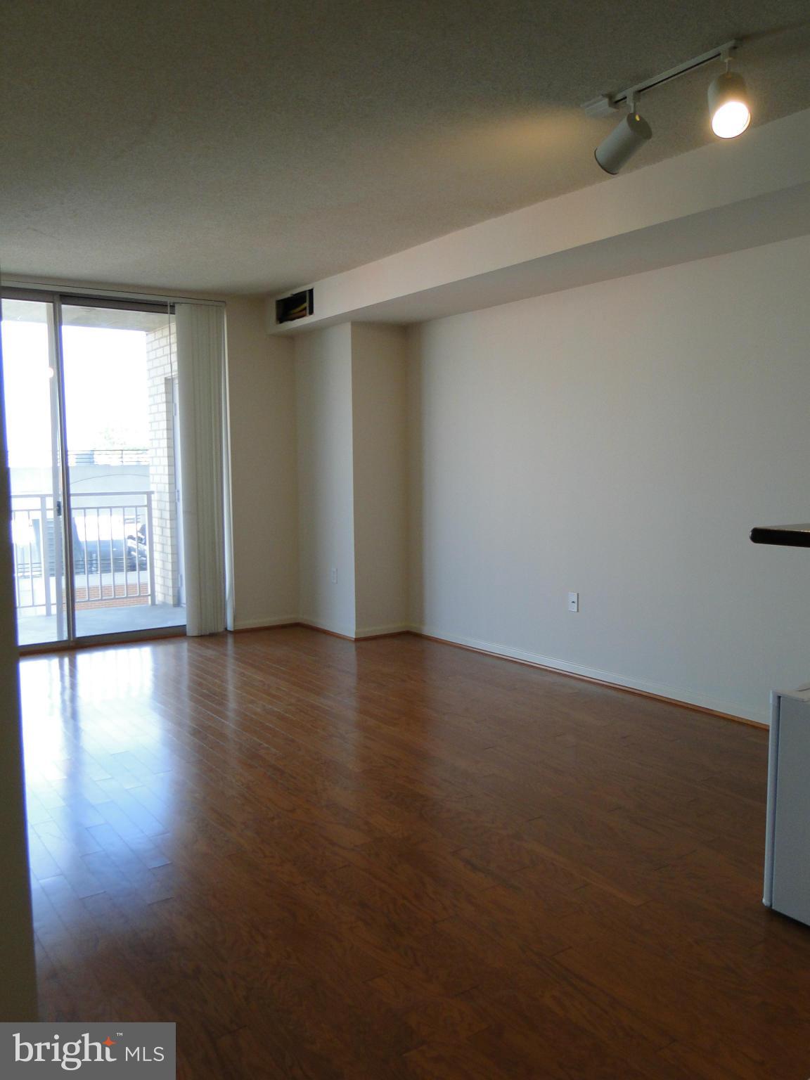 2726 Gallows Road, Unit 611 Vienna, VA 22180 - Photo 7 of 29 a view of an empty room with wooden floor and a window