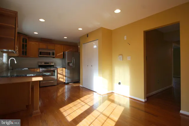 a view of kitchen with stainless steel appliances granite countertop a refrigerator and a stove top oven
