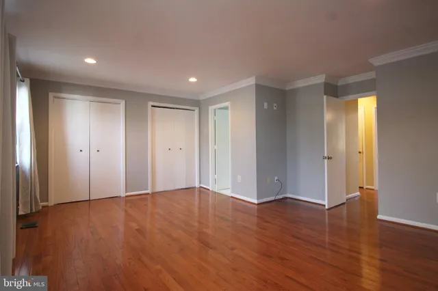 a view of an empty room with wooden floor