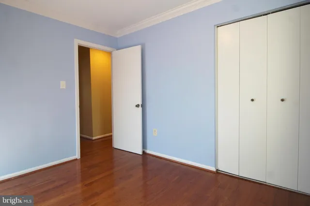 an empty room with wooden floor and closet