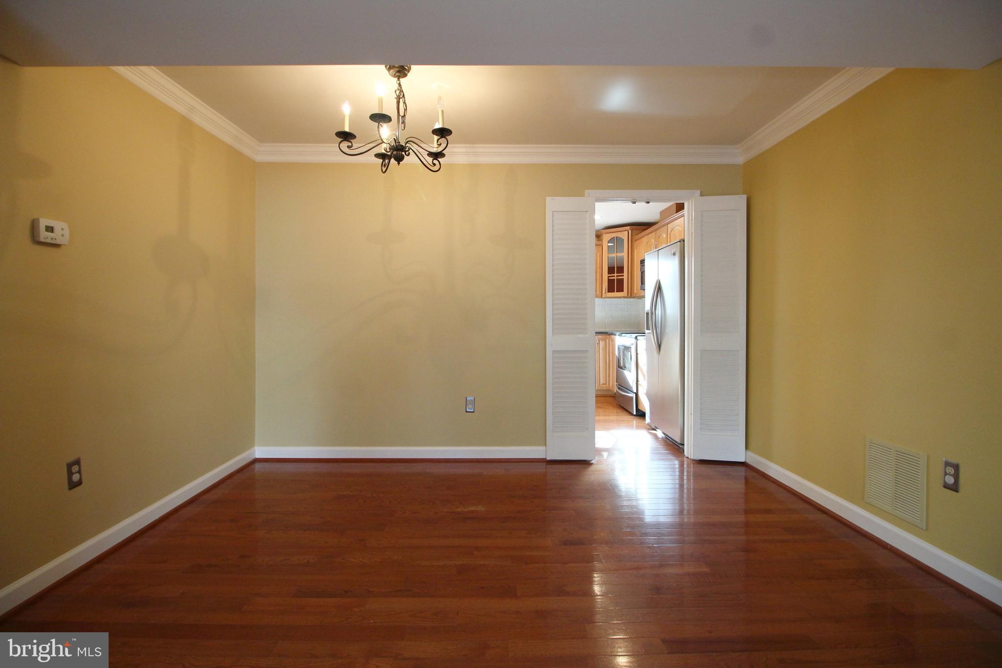 8072 Sleepy View Lane Springfield, VA 22153 - Photo 7 of 30 a view of an empty room with wooden floor and a window