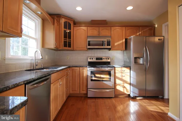 a kitchen with stainless steel appliances a refrigerator sink and microwave