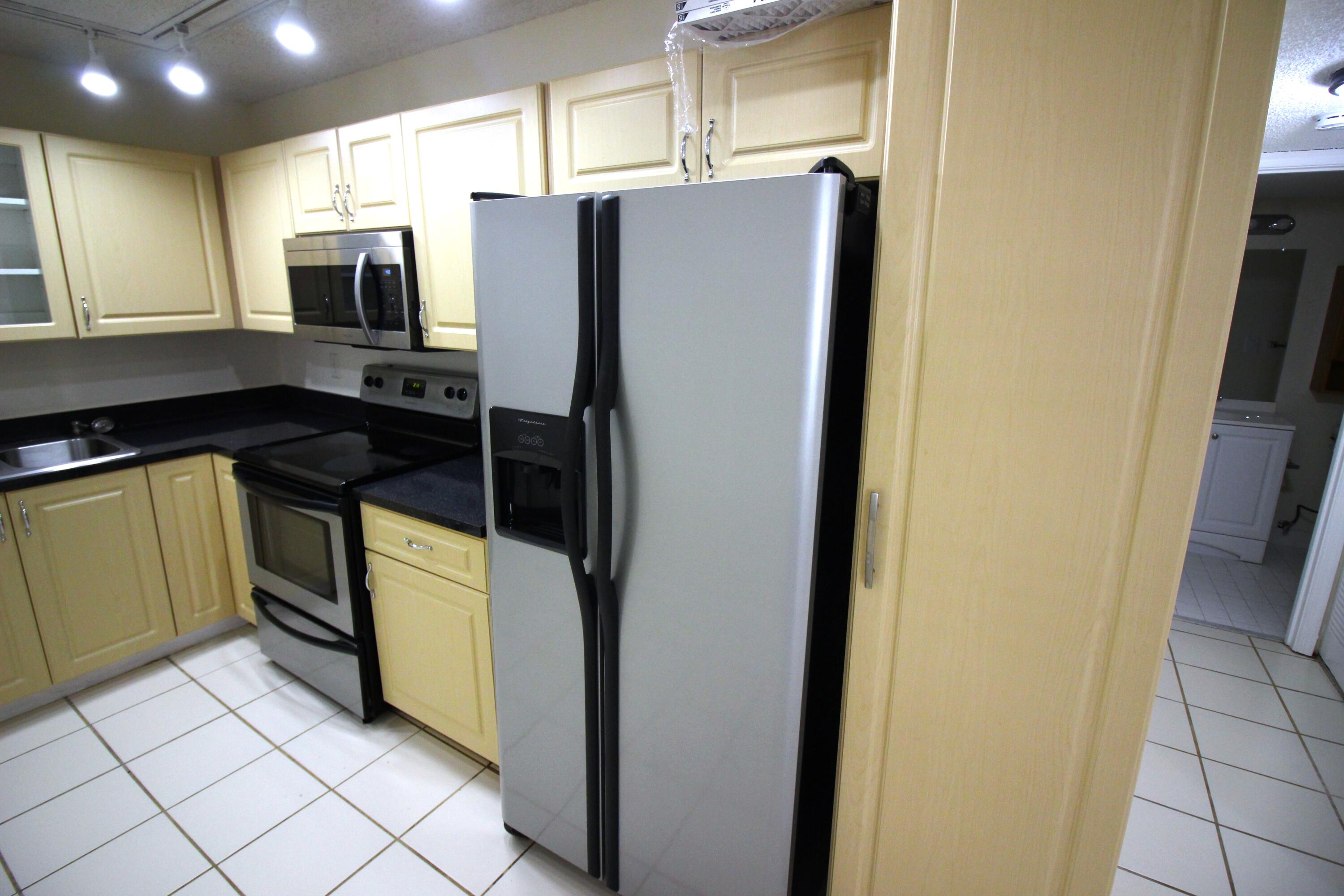 320 Olivewood Place, Unit O115 Boca Raton, FL 33431 - Photo 7 of 56 a kitchen with stainless steel appliances a refrigerator and a stove top oven