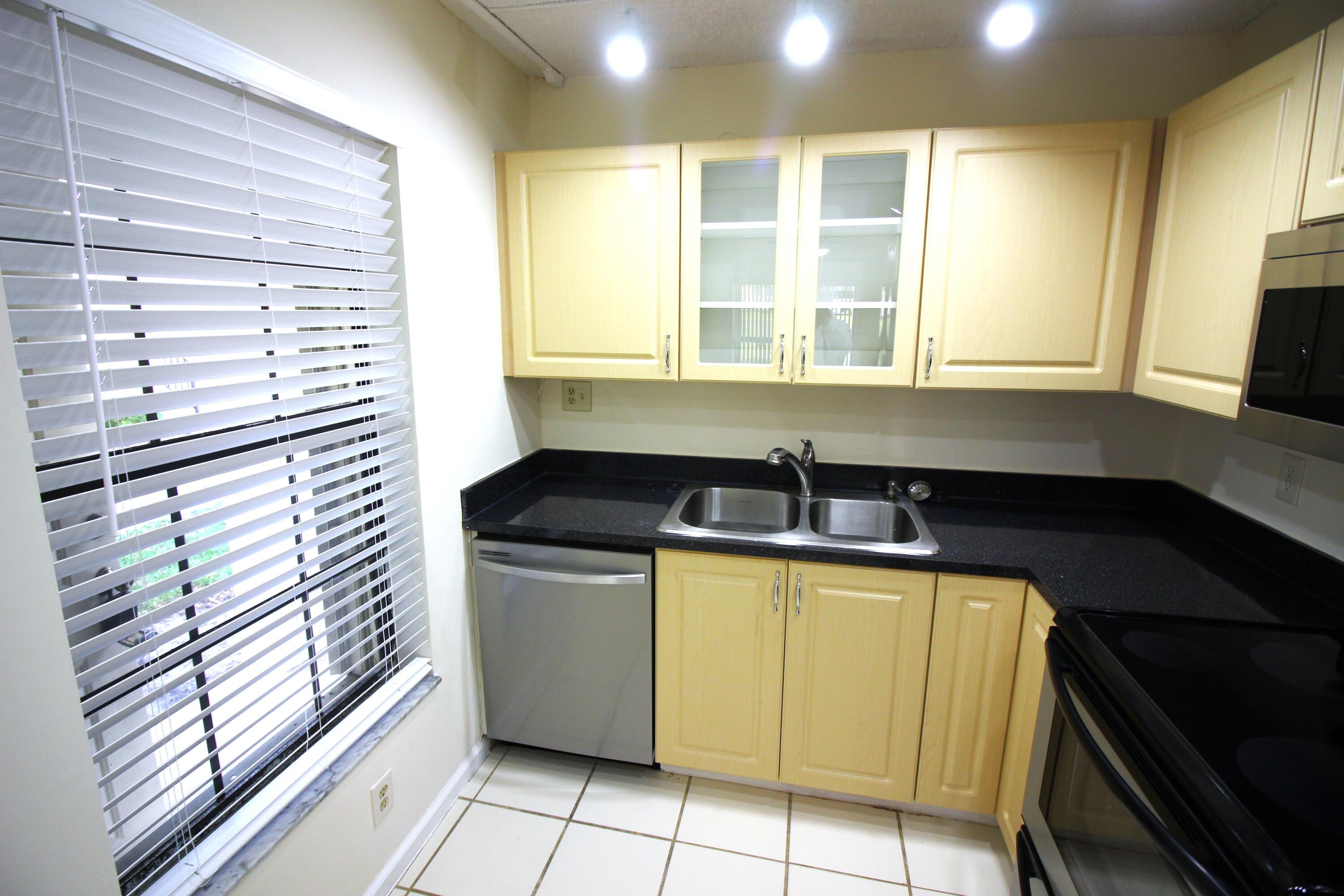 320 Olivewood Place, Unit O115 Boca Raton, FL 33431 - Photo 8 of 56 a kitchen with a sink and a window